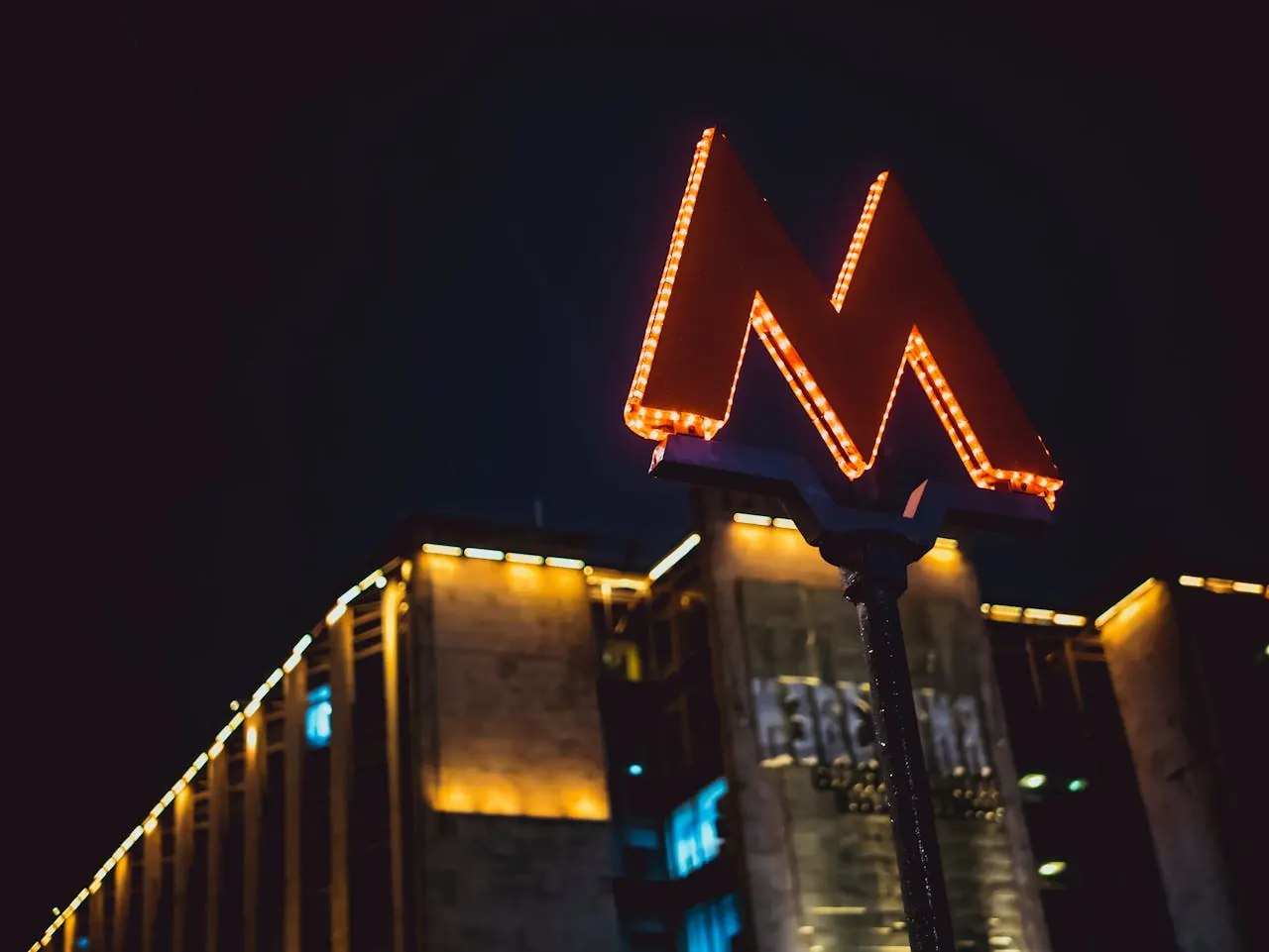 Illuminated casino marquee glowing above a resort tower at night