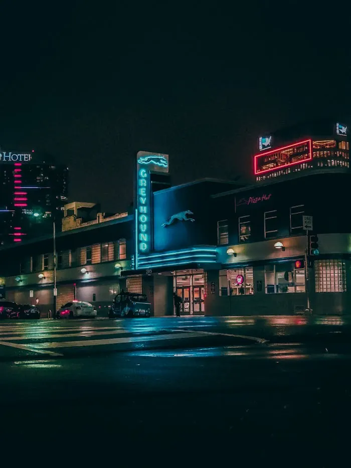 Neon signs glowing along a quiet street after dark
