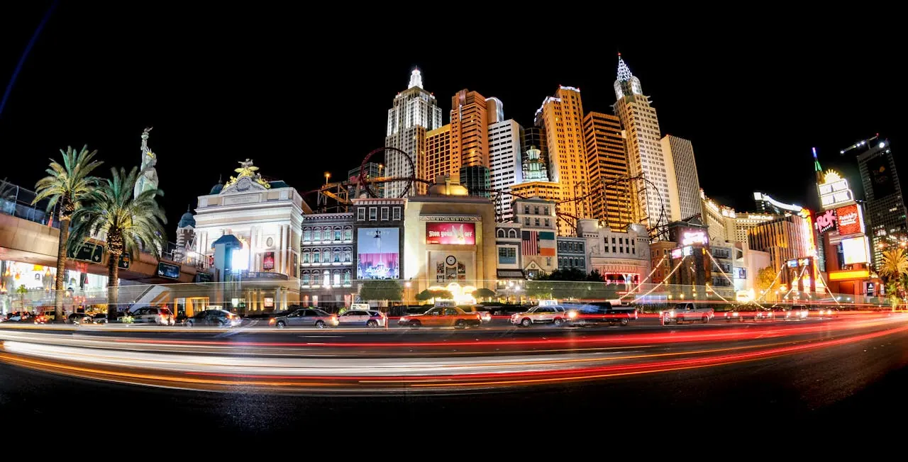 Long-exposure traffic trails along a casino-lined strip at night